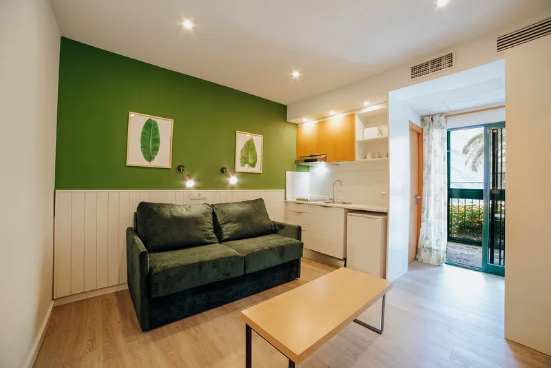 Palm Court: Living area, Green sofa, coffee table and kitchenette