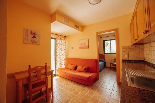 Palm Court: Apartment, Orange sofa, dining table and kitchen units