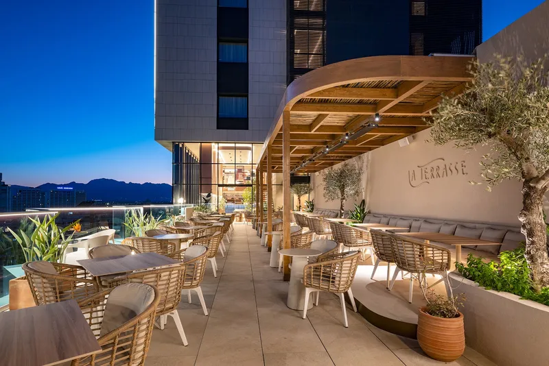 Port Benidorm: Terrace bar, Terrace with wicker chairs and an olive tree at dusk