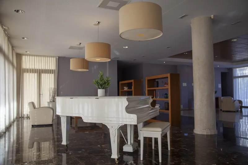 Benidorm Poniente: Lounge, Lounge with white grand piano and bookshelves