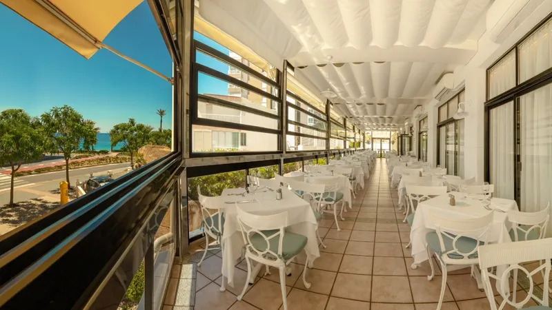 Corona del Mar: Terrace restaurant, Covered glazed terrace with rows of white-clothed tables