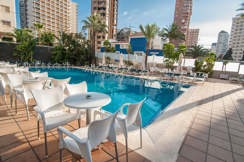 RH Royal: Pool terrace, Pool with white terrace chairs and towers behind