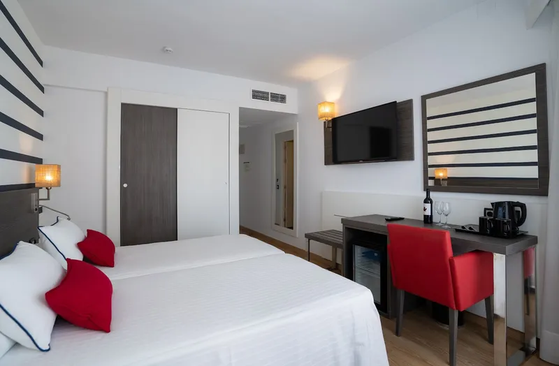 Riudor: Twin room, Twin beds with red cushions, desk and TV