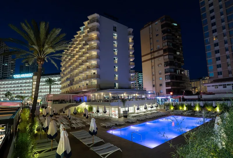 Riudor: The hotel at night, Lit pool and loungers below the hotel at night