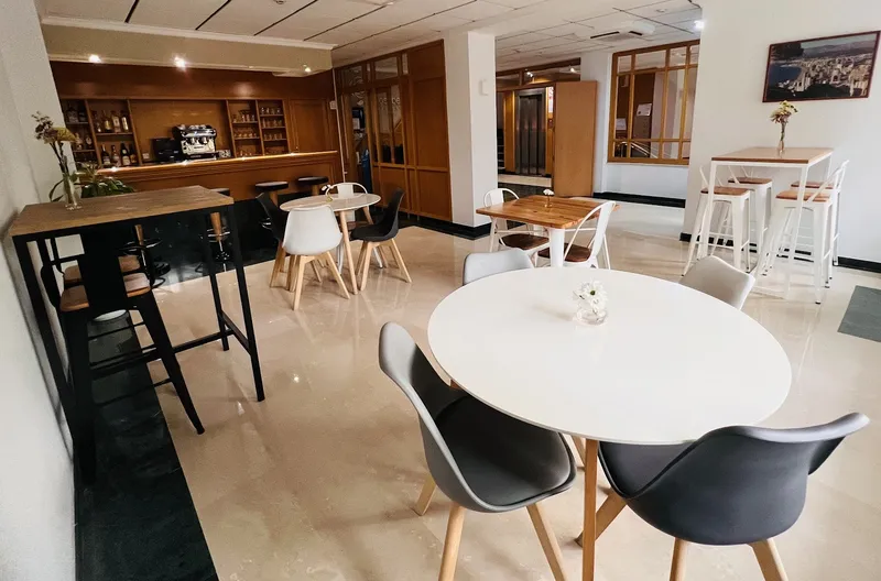 Rosabel: Bar and lounge, Round and high tables in front of a wooden bar