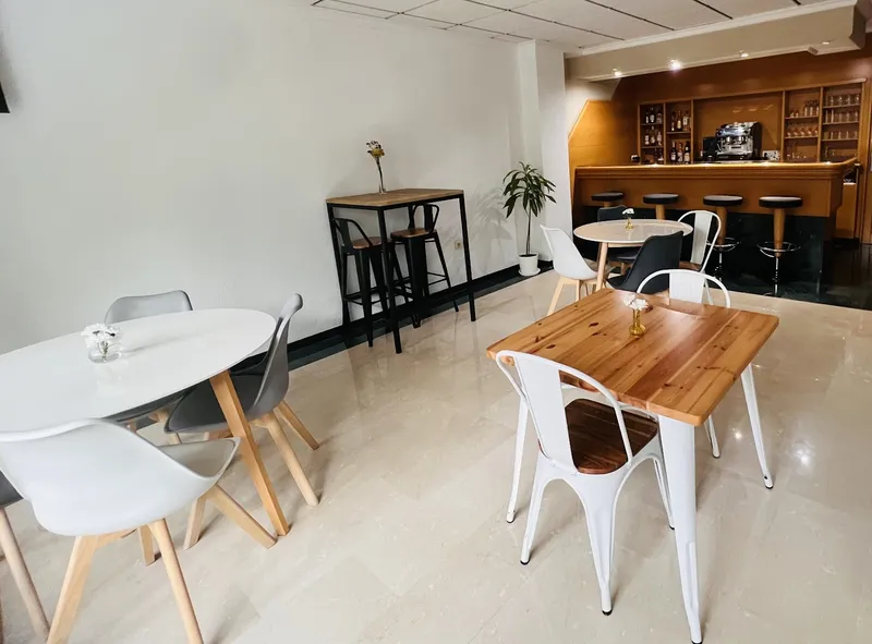 Rosabel: Café bar, Wooden and white tables with a bar counter behind