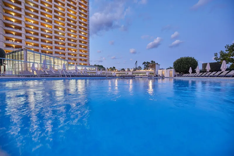 Sandos Suites: Pool at dusk, Pool with hotel tower in evening light