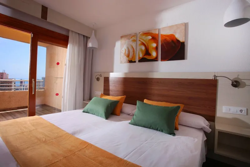 Sandos Suites: Twin room, Two beds with green cushions and balcony doors