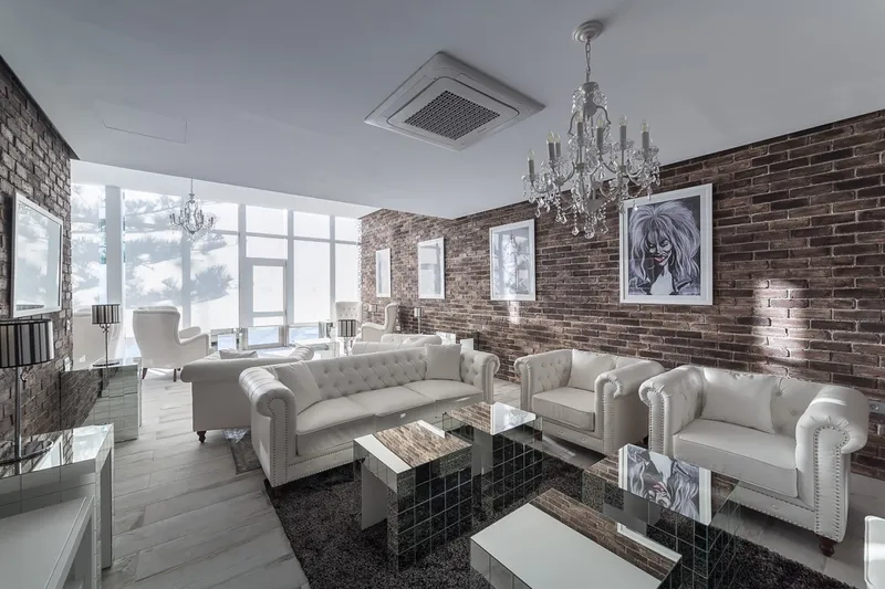 Sandos Suites: Lounge, White sofas, chandelier and brick wall