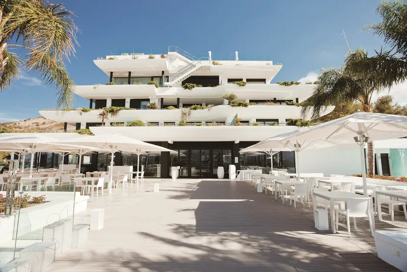 SHA: Terrace, Terrace with white tables and parasols below the building