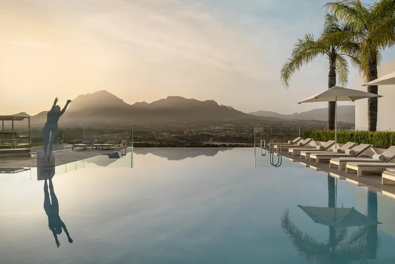SHA: Infinity pool, Pool with a statue, loungers and mountains at dusk