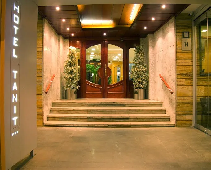 Tanit: Entrance, Steps up to wooden doors with Tanit sign