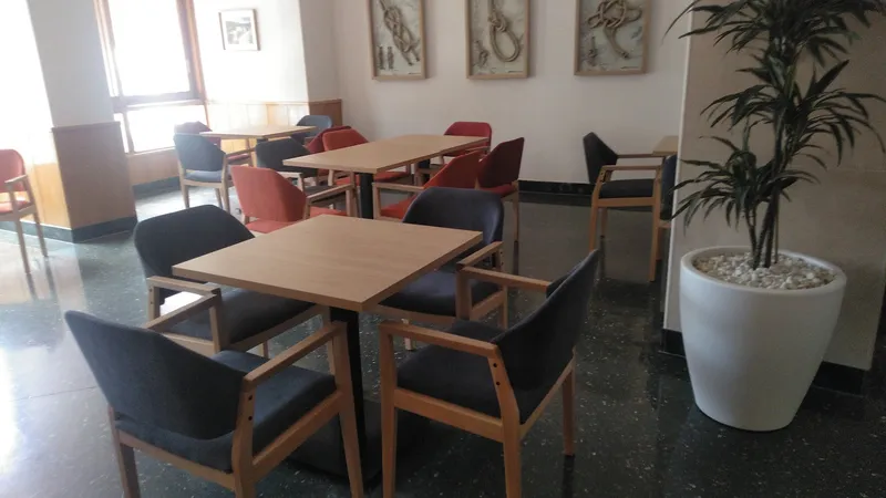Tanit: Dining room, Wooden tables and chairs beside a potted palm