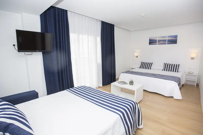 Voramar: Twin room, Twin beds with striped covers and navy curtains