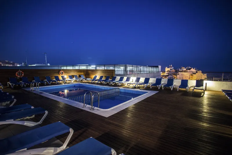 Voramar: Rooftop pool, Rooftop pool and loungers on a wooden deck at night
