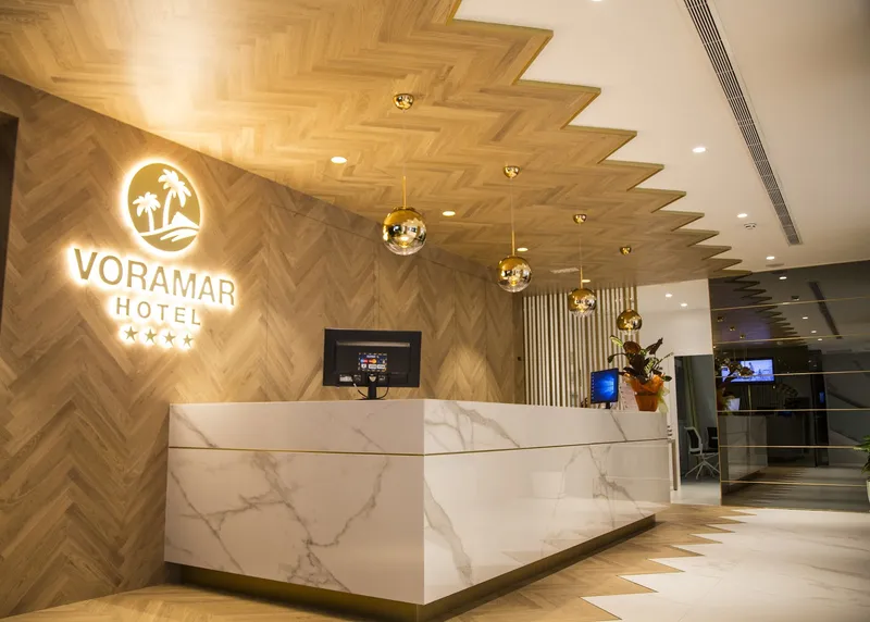 Voramar: Reception, Marble reception desk with a lit Voramar Hotel sign