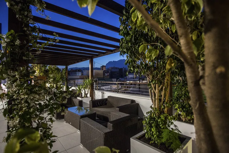 Voramar: Roof terrace, Terrace with rattan sofas and plants, mountains behind