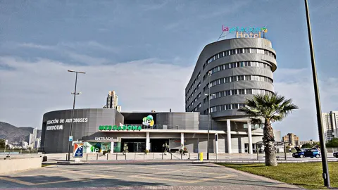 Benidorm bus station (Estación de Autobuses), with the round Hotel La Estación behind. Airport coaches stop here.